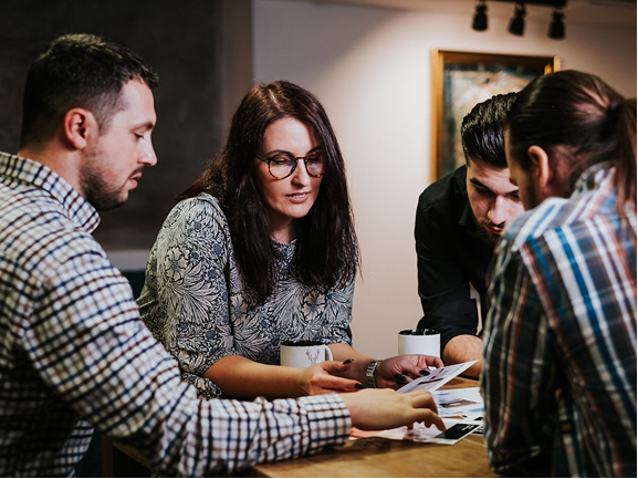 Team arbeitet gemeinsam am Tisch als Symbol für MPoweredHub, persönliche Beratung, gelebte Zusammenarbeit, CRM-Expertise und erfolgreiche digitale Prozessoptimierung.
